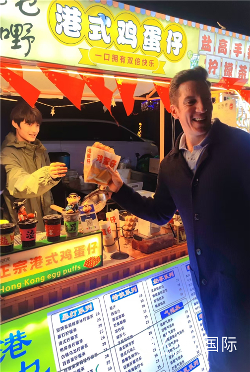 夜市の軽食を味わう観光客（撮影?張璐璐）。