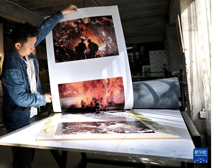 12月9日、雲(yún)南普洱學(xué)院那柯里絶版木刻教學(xué)実踐拠點(diǎn)で刷り上げた作品を見せる同拠點(diǎn)の責(zé)任者を務(wù)める絶版木刻作家の冷光冕さん。