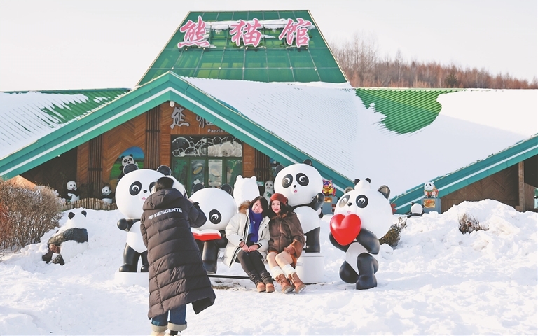 パンダのオブジェの前で寫(xiě)真を撮影する女性たち（撮影?張澍）。