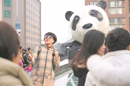 四川省成都市のショッピングモール「IFS」の前で寫真を撮影する外國人観光客。