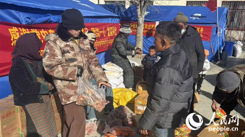 被災(zāi)者に物資を配る90後(1990年代生まれ)の農(nóng)村振興擔(dān)當(dāng)者?格桑卓瑪さん（左から2番目）。撮影?瓊達(dá)卓嘎