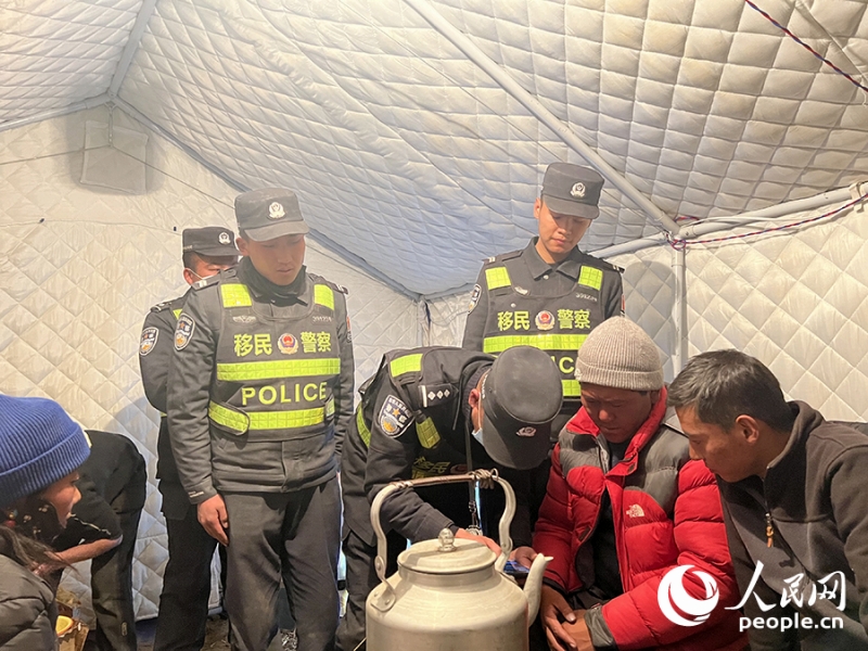 火災(zāi)予防に関する注意喚起をする00後(2000年以降生まれ)の洛桑多吉（立っている男性の左から2番目）と馬楽騁さん（立っている男性の1番右）。撮影?瓊達(dá)卓嘎