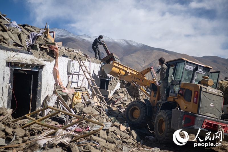 1月13日、倒壊した家屋のがれきを片付ける長(zhǎng)所郷嘎旦村の呉堅(jiān)加布?村書(shū)記（左）。撮影?翁奇羽