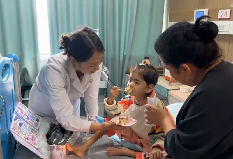 誕生日ケーキを食べる艾力西木ちゃん（畫像提供?浙江大學(xué)醫(yī)學(xué)院附屬児童病院）。