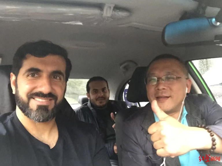 外國人と記念寫真を撮影するタクシードライバーの姚剛さん(寫真右端)。