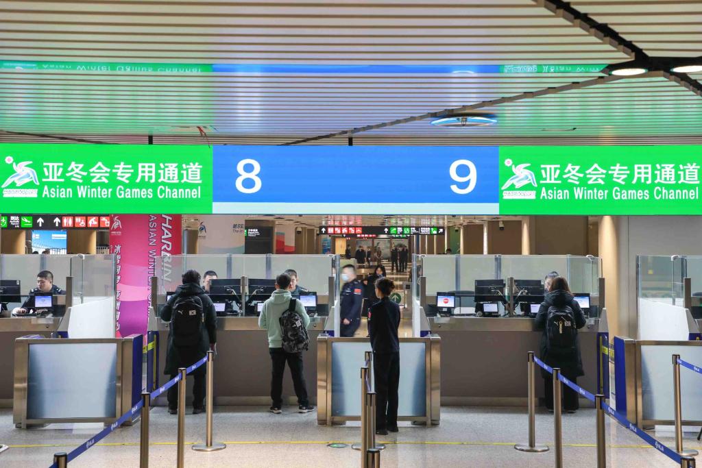 1月26日、中國(guó)の移民管理警察の案內(nèi)の下、出入國(guó)検査所に設(shè)置された第9回アジア冬季競(jìng)技大會(huì)選手?関係者専用ゲートで入國(guó)審査を受ける韓國(guó)の選手?関係者。