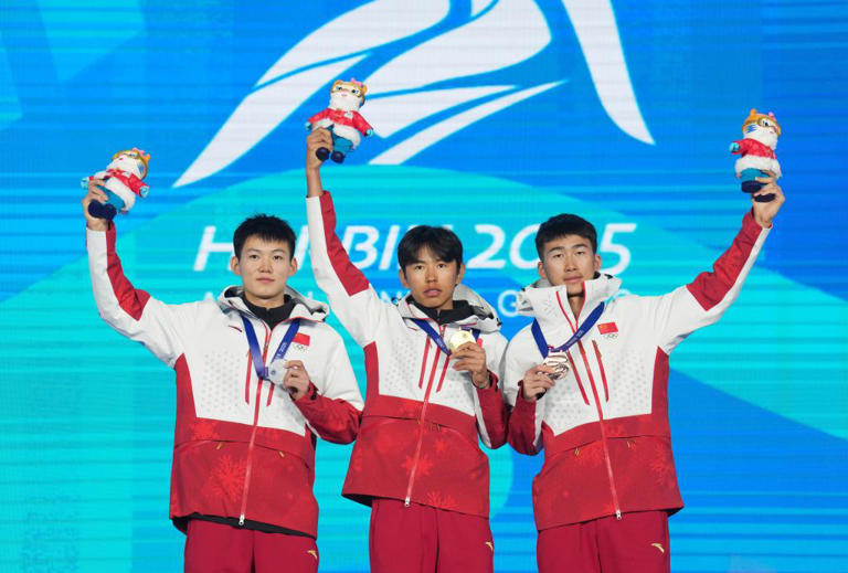 2月9日、表彰臺でガッツポーズする布魯爾選手（寫真中央）、張成浩選手（寫真一番左）、卒禹選手。同日、スキーマウンテニアリング男子スプリント決勝が行われ、中國選手がメダル3個を総なめに（撮影?王松）。