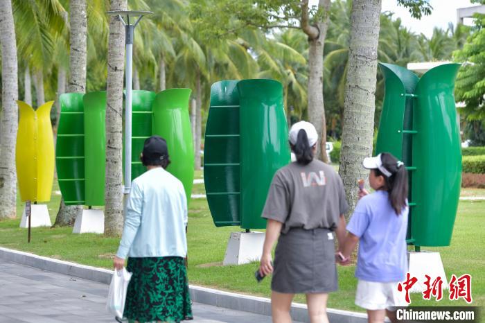 ボアオ?アジアフォーラム國(guó)際會(huì)議センターの両側(cè)に設(shè)置された花の形をした風(fēng)力発電機(jī)を見(jiàn)入る観光客。（資料寫(xiě)真）撮影?駱雲(yún)飛