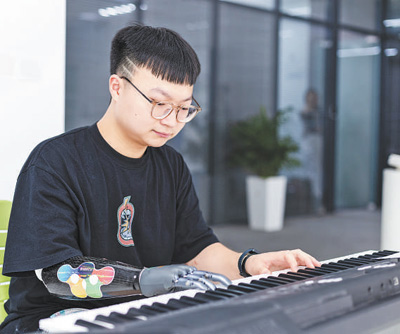 スマートバイオニックハンドを裝著してピアノを弾く周鍵さん（寫真提供?周鍵さん）。