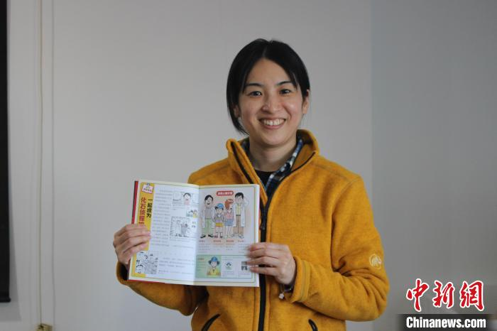 2月25日に北京でインタビューを受ける木村由莉さん。木村さんが見せているのは「化石探偵」のキャラクター紹介ページで、木村さんもキャラクターとして同書に登場している。（撮影?蘇婧欣）