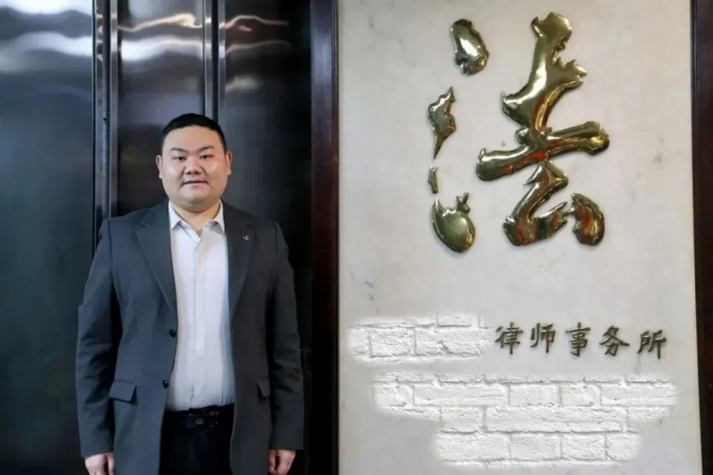 弁護(hù)士事務(wù)所の前に立つ劉政さん（寫真提供?北京大學(xué)）。