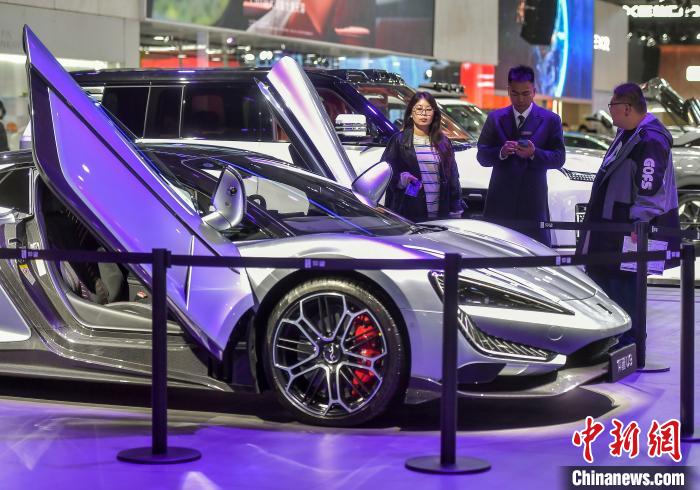 比亜迪（BYD）の高級(jí)ブランド「仰望」の純電動(dòng)スーパーカー「U9」を見(jiàn)る男性たち（撮影?劉新）。