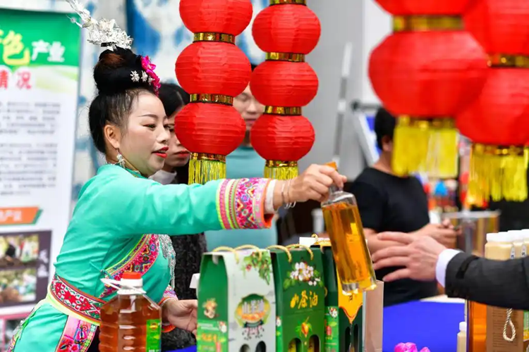 侗族の新年を迎えるに當(dāng)たり、年越し用品マーケットで地元の特産品を売る女性（撮影?楊文斌）。