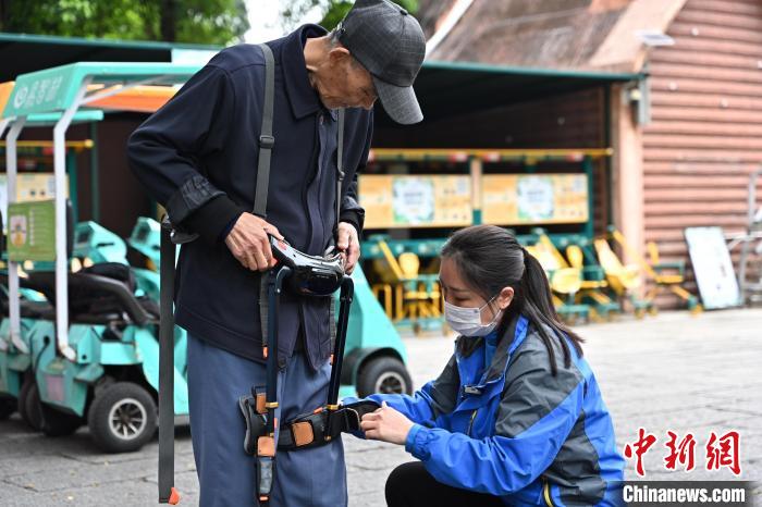 深セン野生動物園のスタッフのサポートを受けながら歩行用外骨格アシストスーツを裝著する邵沢仁さん（3月17日撮影?陳驥旻）。