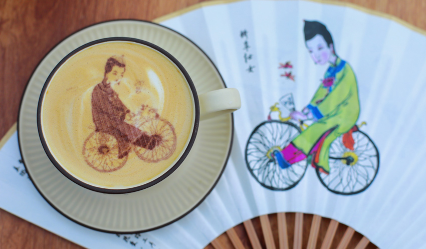 自転車をこぐ女性を描いた年畫のラテアート（寫真提供?綿竹市金申文化旅游開発有限公司）。