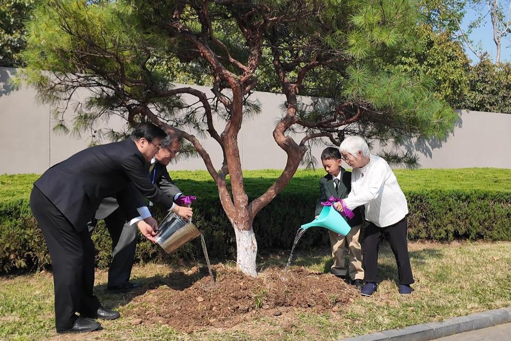 「平和と音楽の木」を一緒に植える日本の「紫金草合唱団」の代表と南京紫金草童聲合唱団の代表（撮影?毛?。?></p>
<p style=