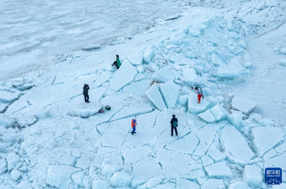 興凱湖の一部に殘っている厚い氷の上で記念撮影などをする観光客（3月31日、ドローンによる撮影?謝剣飛）。