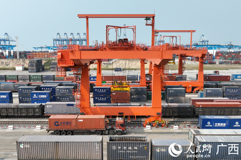 広西壯（チワン）族自治區(qū)欽州市の鉄道コンテナセンター駅で、自動化ガントリークレーンが自動車輸送コンテナ貨物を吊り上げている様子。（撮影?王勇）