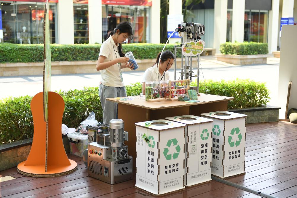 ボアオ?ゼロカーボンモデルエリアのプラスチックリサイクル工程科學展示ブースで、プラスチックのリサイクル工程を説明する職員（3月25日撮影）。撮影?謝子蕓