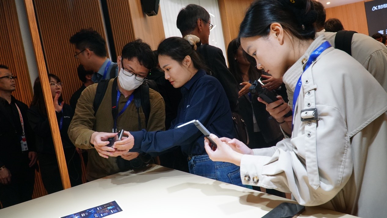 発表會では、科大訊飛のデュアルスクリーン翻訳機2.0を試用する來場者。（撮影?蔣暁辰）