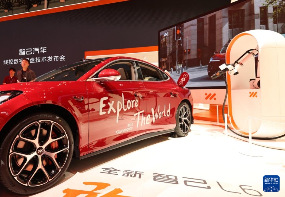 展示ブースで、ロボットアームによる充電デモンストレーションを行うスマートカー（4月23日撮影?方喆）。