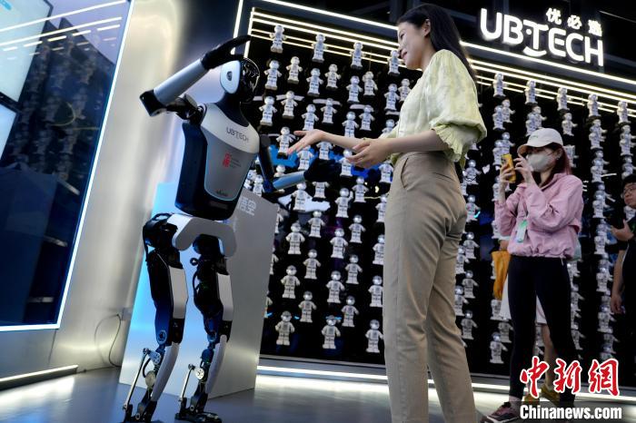 來訪者と交流する深セン優(yōu)必選科技股份有限公司が研究開発した人型ロボット（4月23日撮影?朱賀）。