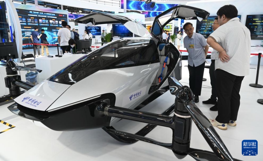 29日、第8回デジタル中國建設(shè)サミットの體験エリアで展示された有人ドローンを見學(xué)する來場者。