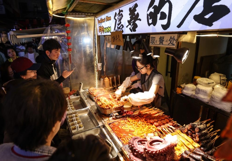 瀋陽(yáng)市西塔商業(yè)圏でストリートフードを購(gòu)入する観光客ら（5月2日撮影?潘昱龍）。