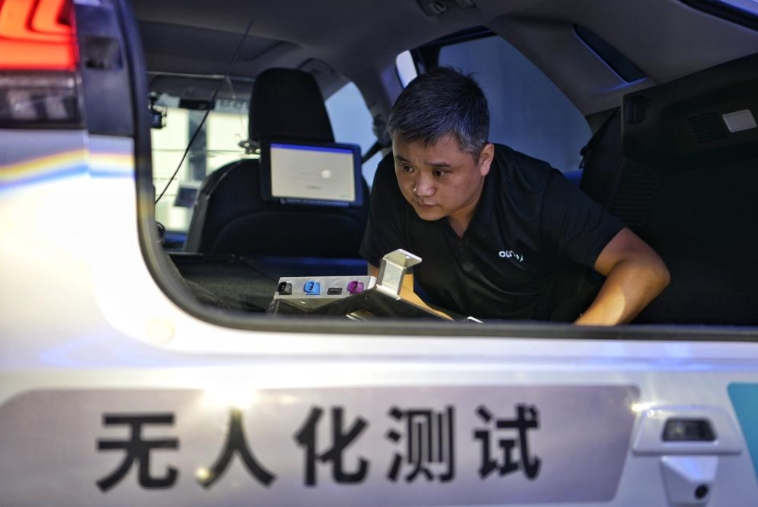北京の小馬智行（Pony.ai）亦荘運(yùn)営センターで、自動(dòng)運(yùn)転テストを行う車両に搭載されている設(shè)備をチェックするスタッフ（2024年6月19日撮影?辛悅衛(wèi)）。
