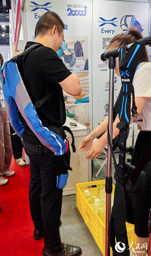 「マッスルスーツ」を試用する來(lái)場(chǎng)者（撮影?張靖）