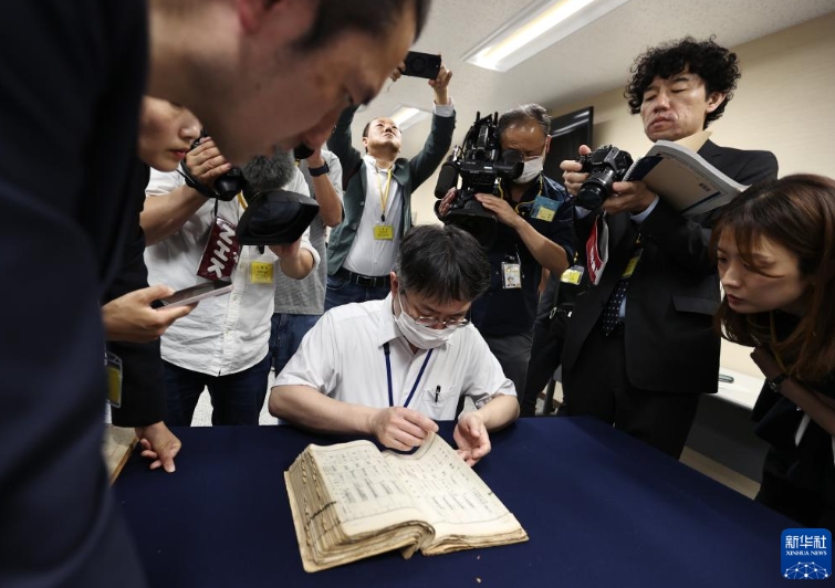 東京の國立公文書館で、中國侵略日本軍細菌戦部隊「登第1644部隊」の留守名簿から、竹上勝利さんの父親?宮下利市さんに関する記録を探す職員（5月14日撮影?賈浩成）。