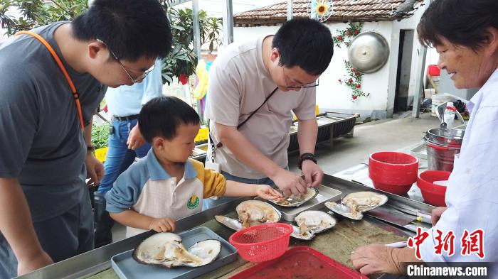 「珠出し」を體験する親子（6月2日撮影?曹丹）。