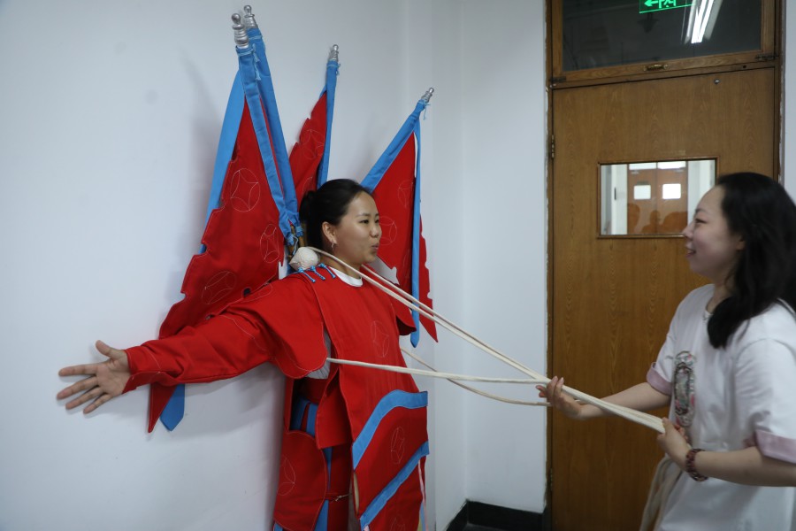 文化講座で武將役の衣裝の試著を體験するモンゴル人留學(xué)生の薩仁高娃さん（寫(xiě)真提供?中國(guó)戯曲學(xué)院/撮影?沈欣冉）。