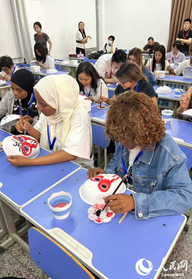 臉譜（隈?。┙}畫(huà)體験で紙製のお面に孫悟空の隈取を真剣な面持ちで描く留學(xué)生たち（撮影?玄番登史江）。