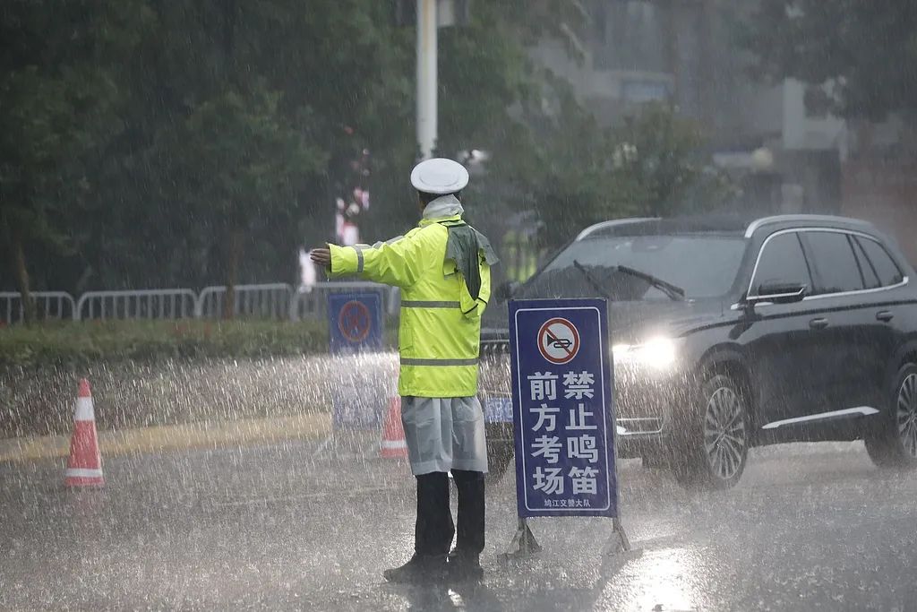 6月7日、雨天となった安徽省蕪湖市第一中學(xué)校の試験會場前で、受験生が安全に試験會場に向かうことができるよう、交通整理を行う警察官。