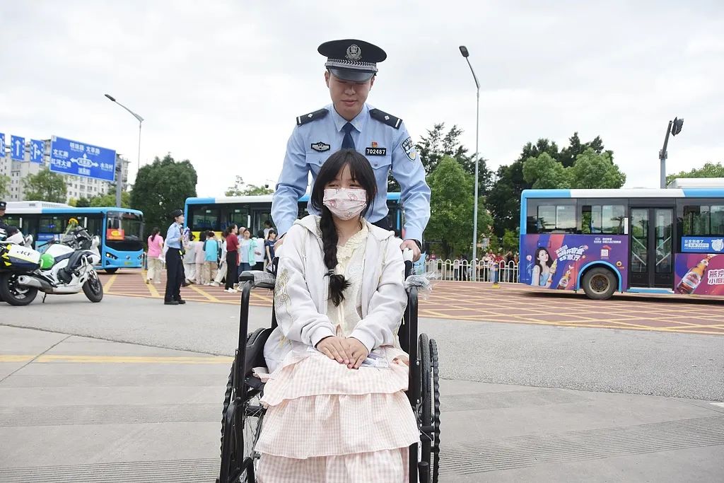 6月7日、雲(yún)南省紅河哈尼（ハニ）族彝（イ）族自治州の蒙自市第一高級中學(xué)校の試験會場前で、車椅子に乗った受験生を試験會場まで送る警察官。