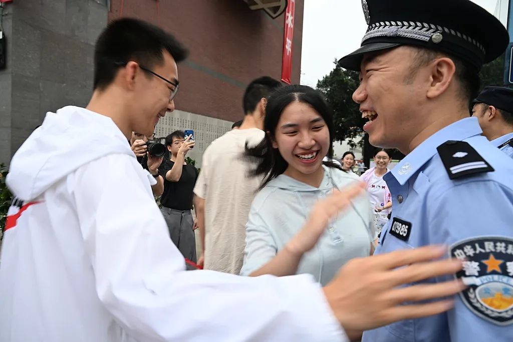 四川省の成都玉林中學(xué)校の試験會場前で、識別番號の下三桁が「985」の警察官の周りに集まる受験生。中國では中國政府が重點的に建設(shè)を進める「985プロジェクト」の対象となった大學(xué)が「985」大學(xué)と呼ばれている（6月7日撮影?張浪）。