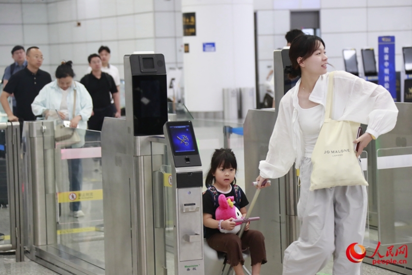 入國手続きを終えてゲートから出てくる親子（撮影?霍亜平）。