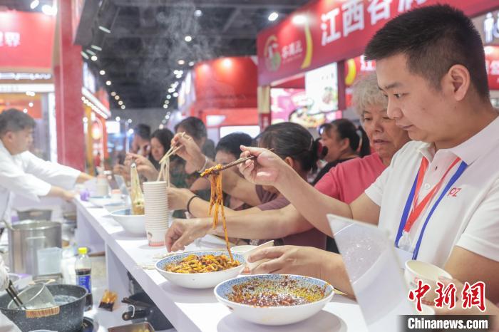2025ライスヌードル産業(yè)交易會のある企業(yè)ブースでライスヌードルを食べる來場者。（6月13日撮影?劉力鑫）