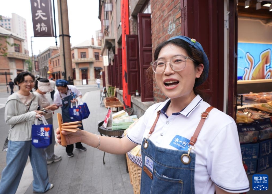 大連市の東関街歴史文化街區(qū)で、快板（竹製の板を打ち合わせてリズムを刻みながら、早口で物語(yǔ)や口上を語(yǔ)る中國(guó)の伝統(tǒng)蕓）のリズムに乗せて食品を宣伝販売する販売員（6月13日撮影?李剛）。