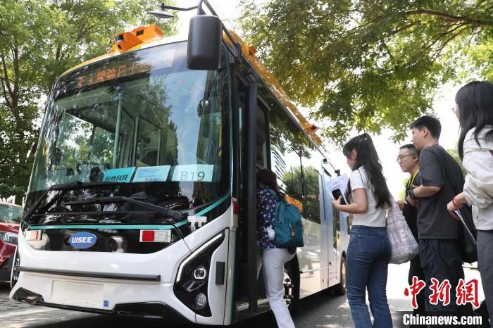 16日、北京市中関村新興産業(yè)先端技術(shù)研究院の構(gòu)內(nèi)で自動(dòng)運(yùn)転バスを體験する人々。撮影?王紫儒