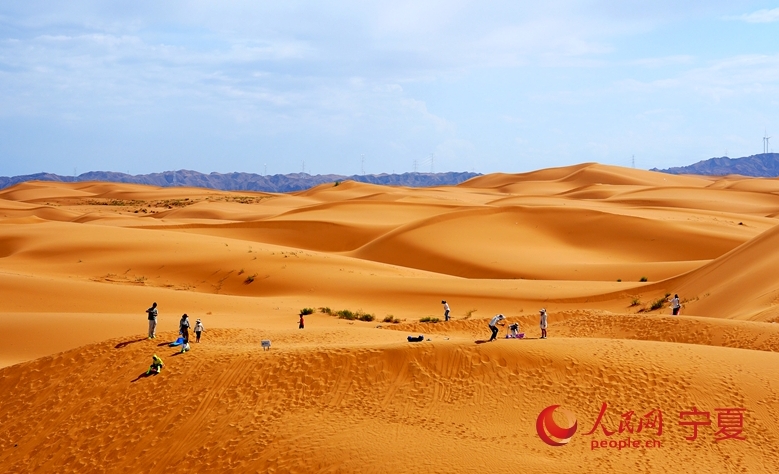 砂漠で遊ぶ観光客（撮影?周航）。