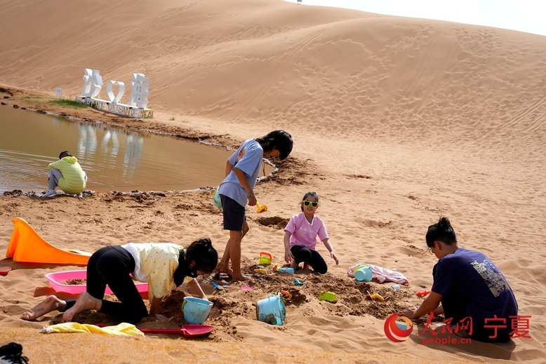 砂で遊ぶ女の子たち（撮影?周航）。