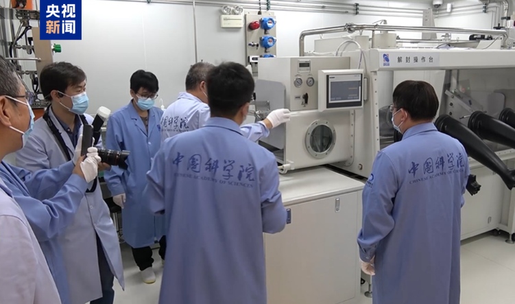 サンプルの密封裝置を開封作業(yè)臺に移す研究チーム