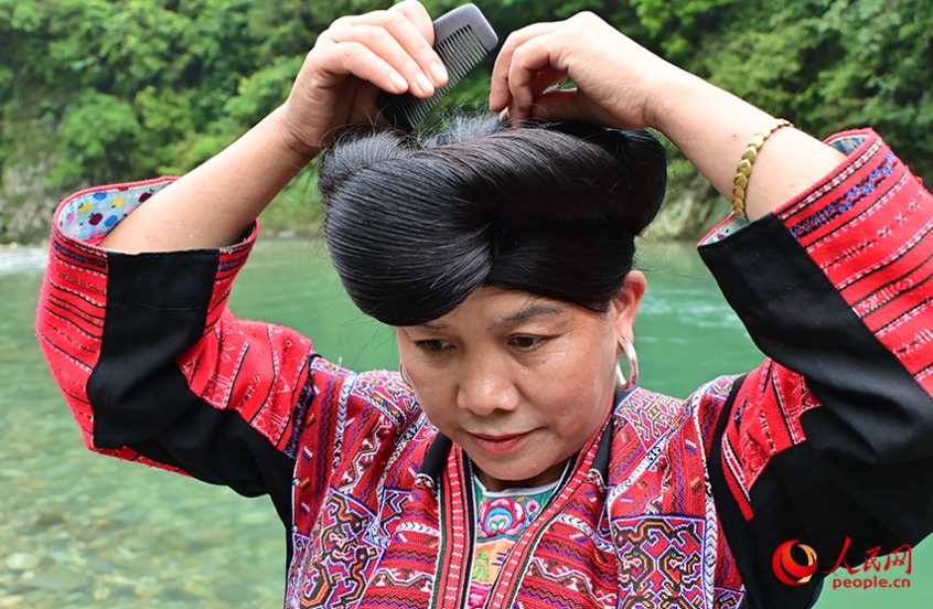 髪を結(jié)う紅瑤の女性。（撮影?雷琦竣）