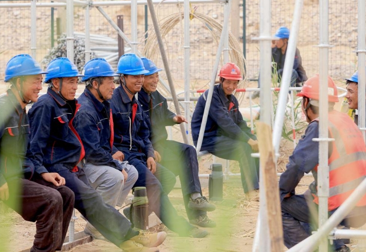 7月10日、工事現(xiàn)場(chǎng)での休憩時(shí)間に雑談する陳林さん（左から4人目）と同僚。