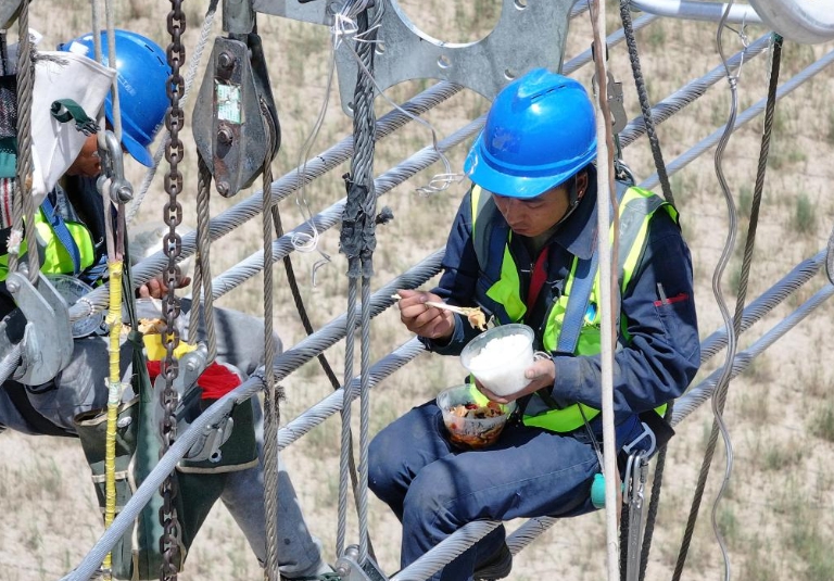 7月13日高さ70メートルの鉄塔の上で晝食を取る陳林さん（寫(xiě)真右、ドローンによる撮影）