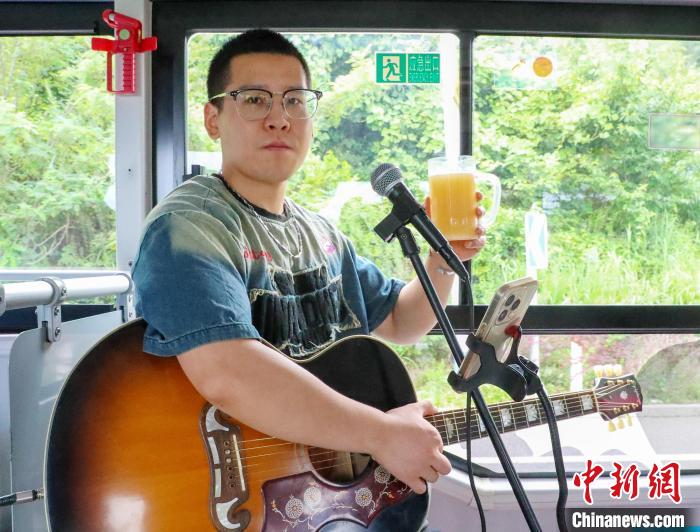 バスの車內(nèi)で、歌唱の合間にビールを味わう歌手（7月16日撮影?張進(jìn)剛）