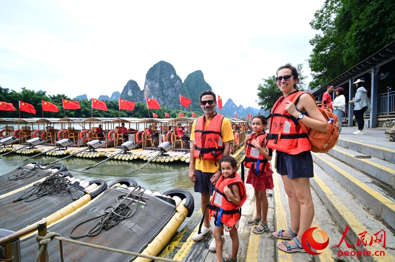 漓江の風(fēng)景を楽しもうと、竹のいかだに乗り込むスペインからの観光客。（撮影?雷琦竣）