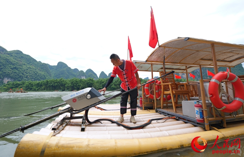 竹のいかだを操縦する鄭海波さん。（撮影?梁章暉）